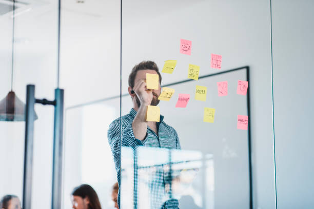 istock Businessman writing new ideas on adhesive notes in the office during a meeting 1004862374