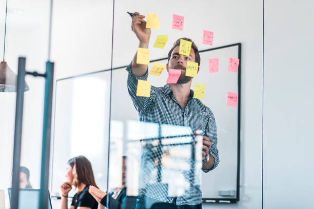 istock Businessman writing new ideas on adhesive notes in the office during a meeting 1004862380