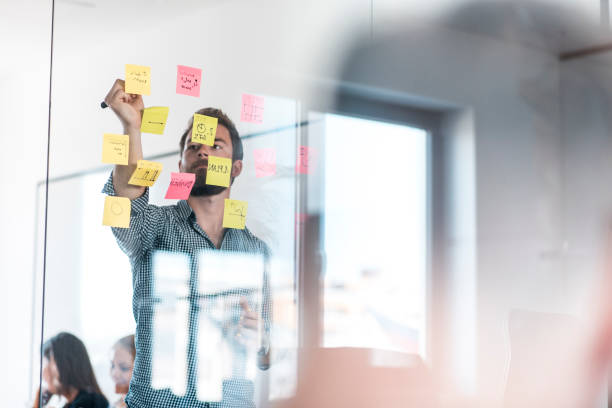istock Businessman writing new ideas on adhesive notes in the office during a meeting 1004862384