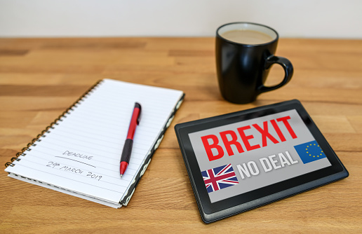 Tablet device on a table with a notebook and coffee mug. The Brexit deadline is 29th March 2019 when the UK leaves the EU.