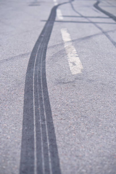 resumo das rodas de pneu preto, causada pelo carro de drift na estrada. em uma passagem para pedestres e uma estrada com as marcas de travagem. fotografia para o projeto - skidding accident car tire - fotografias e filmes do acervo