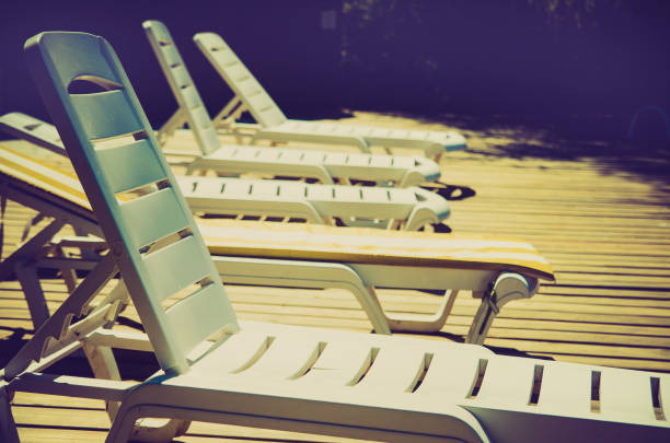Striped red and white loungers near the swimming pool on a summer day. Sun chairs at the pool