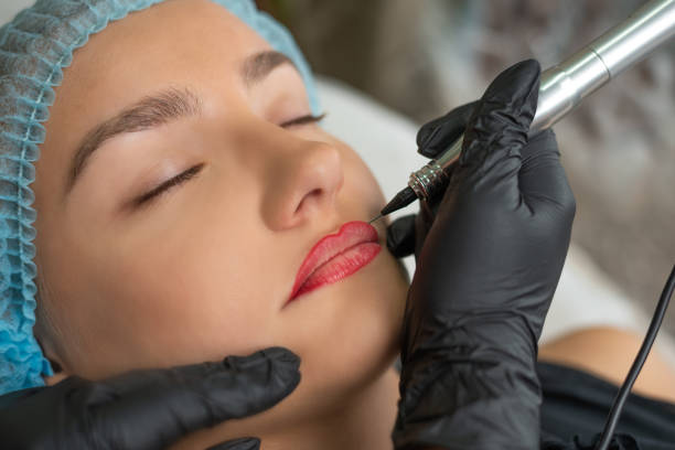 a young girl having lips permanent makeup, micropigmentation. - portrait tattoo photography color image imagens e fotografias de stock