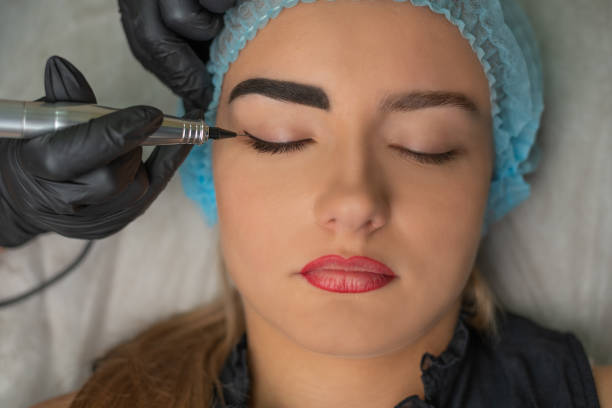 istock A young girl having eyeliner and eyebrows, permanent makeup, micropigmentation. 1004882234