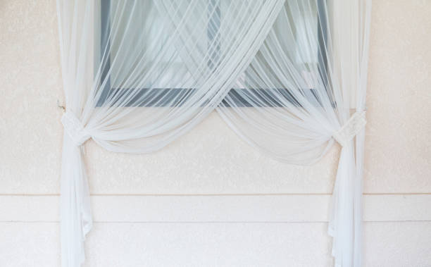 istock Interior white curtain against window and wall. 1004890042