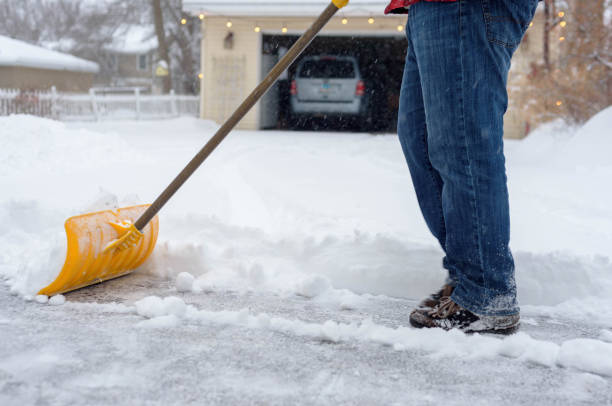 istock Low Section Of Man Cleaning Snow On Road 1004894806