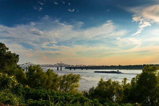 Boat in the Mississippi River near the Vicksburg Bridge in Vicksburg at sunset, Mississippi, USA