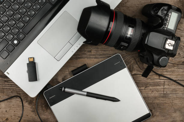 Top view of designers table with laptop computer, drawing tablet, photo camera and flash drive. Top view of designers table with laptop computer, drawing tablet, photo camera and flash drive. Photographer deadline concept. wooden flash drive stock pictures, royalty-free photos & images