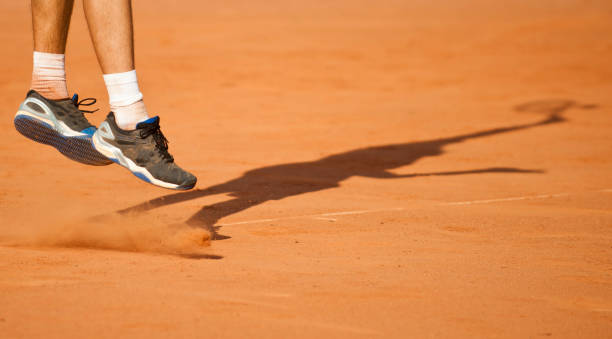 istock Low Section Of Tennis Player Jumping While Playing On Ground 1004914378
