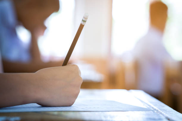 istock Examination in school concept. student writing answer the question of multiple choice test 1004923076