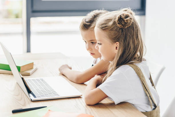 istock little schoolgirls using laptop for studying isolated on white 1004936724