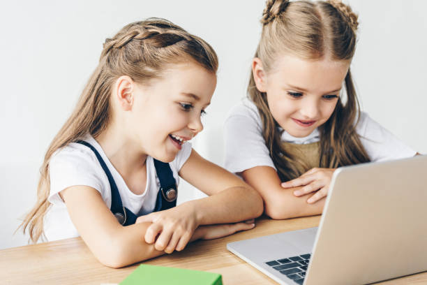 istock smiling little schoolgirls using laptop for studying isolated on white 1004936734