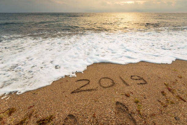 istock 2019 handwritten in sand of tropical beach. 1004943174