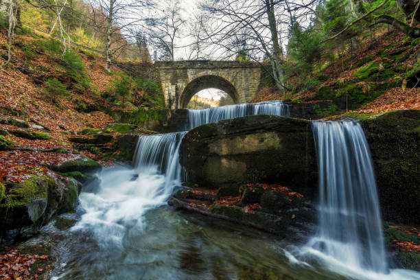 istock Beautiful autumn waterfall in the forest. 1004943202