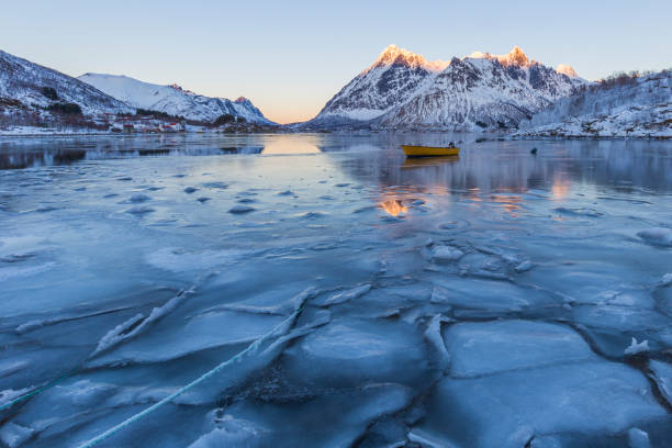 scène hivernale de bateau dans partiellement gelé fjord et paysage de montagne enneigée - cold frozen sea landscape photos et images de collection