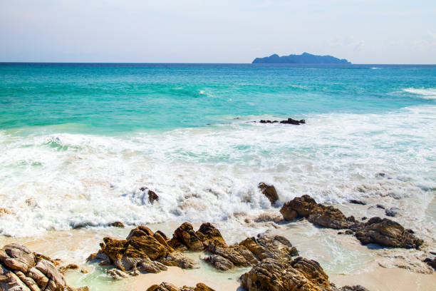 istock Splashing waves on the rocks and blue sky 1004952076