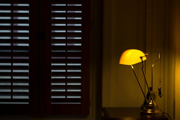istock its dark outside the plantation shutters while a brass lamp shines softly against painted panelling Normandy style, French 1004952688