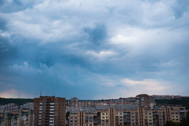 istock Dramatic sky and rain above town. View of town with socialist soviet panel building 1004952716