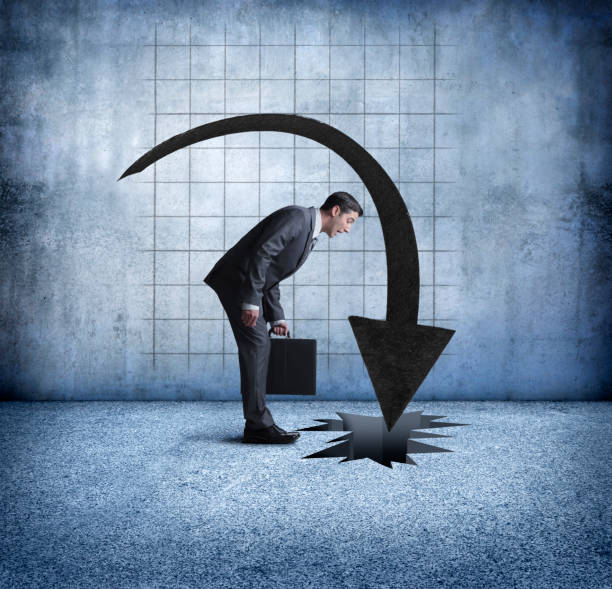 istock Businessman Looks Down At Falling Arrow 1004956326