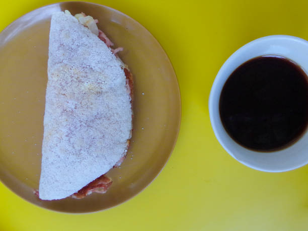 istock Brazilian Stuffed Tapioca. Flatbread made from cassava with chicken, cheese, ham and onion. Tapioca consists in a crepe with grainy made with manioc starch. 1004981078