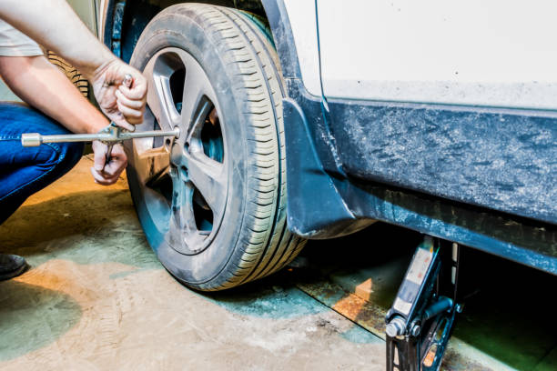 istock Mechanician changing car wheel in garage. Tire service. 1004984150
