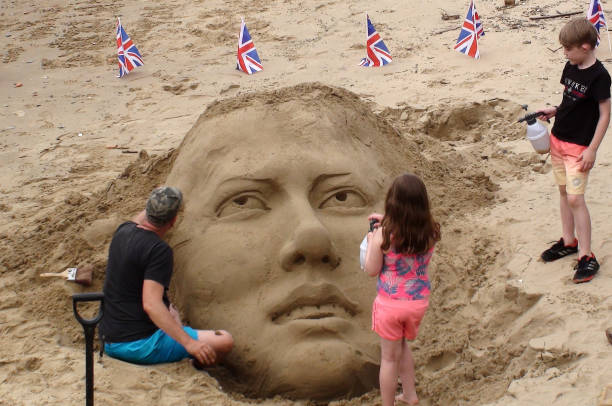 ein mann, eine gesicht-sandskulpturen-szene in england zu schaffen. europa - elizabeth ii queen nobility british flag stock-fotos und bilder