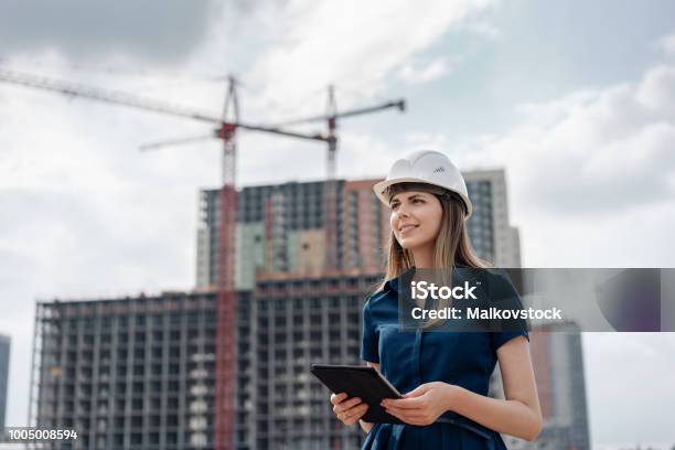 女性の建設エンジニア建設現場でタブレット コンピューターでの建築家します若い女性を探してサイトの場所を背景に構築します建設コンセプト - エンジニアのストックフォトや画像を多数ご用意