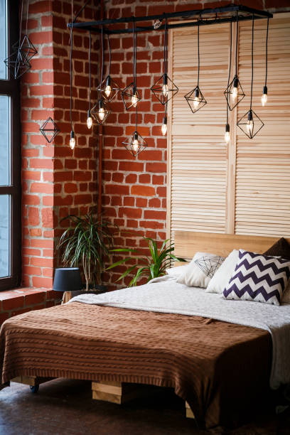 istock Simple bedroom with double bed, red brick wall and big window 1005026778