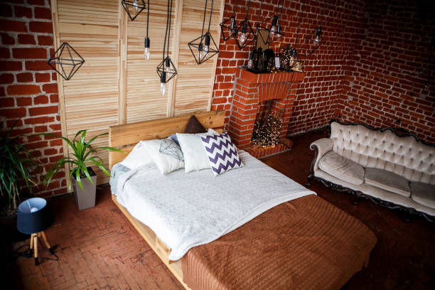 istock Simple bedroom with double bed, red brick wall and big window 1005030904