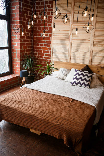 istock Simple bedroom with double bed, red brick wall and big window 1005030922