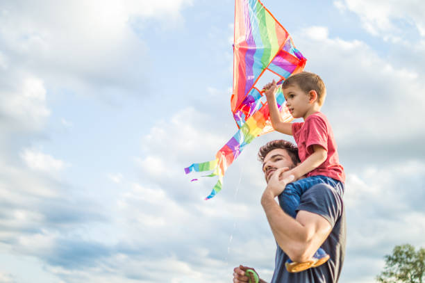 istock Little boy flying a kite with his father 1005032974