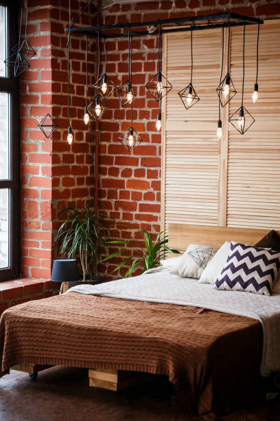 Simple bedroom with double bed, red brick wall and big window