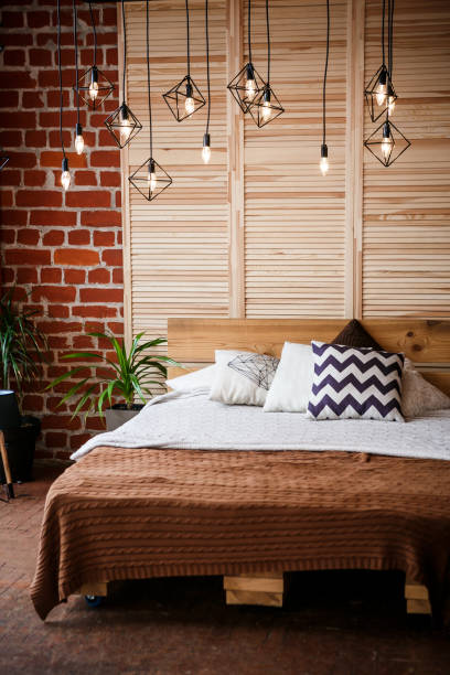 istock Simple bedroom with double bed, red brick wall and big window 1005033130