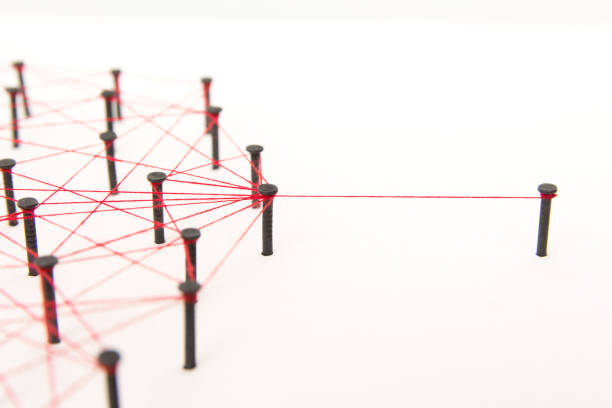 istock Linking entities, social media, Communications Network, one person connected to the rest networks. Network simulation on white paper linked together created by black nail and red thread with copy space 1005040098