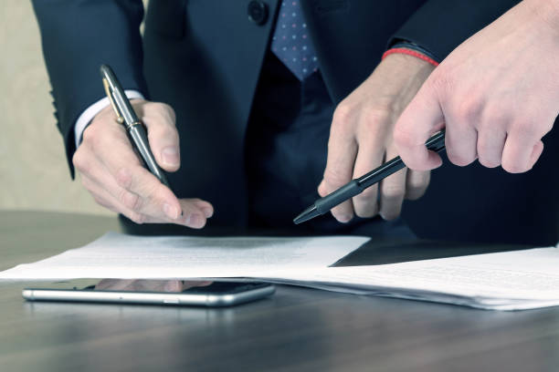 istock hands of business men and women studying the documents 1005042478