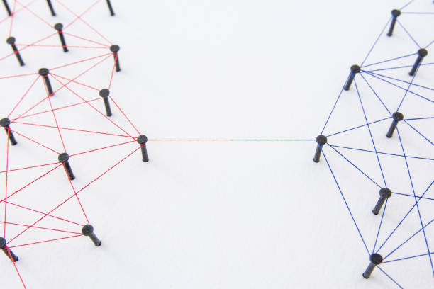 istock Connecting networks concept - two network connected with yarn red and blue on white paper. Simulator connection social media, internet, people communication 1005045964