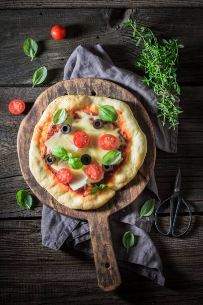 istock Homemade pizza with cheese, tomatoes and herbs 1005048204