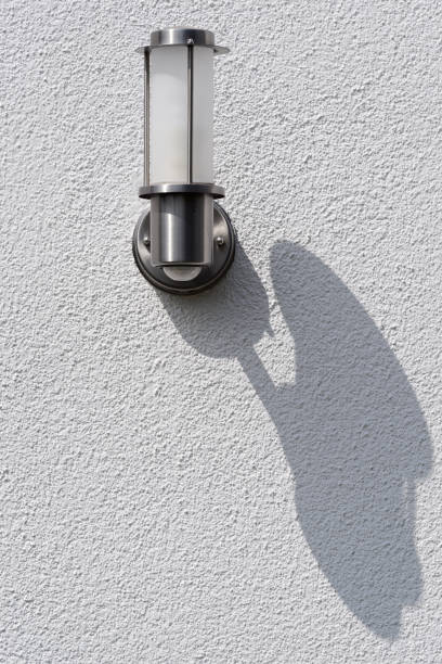 istock White silver outdoor lamp and their shadow on white house wall 1005048558