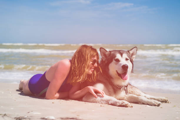 Portrait of happy female in glasses and swimwear with pet