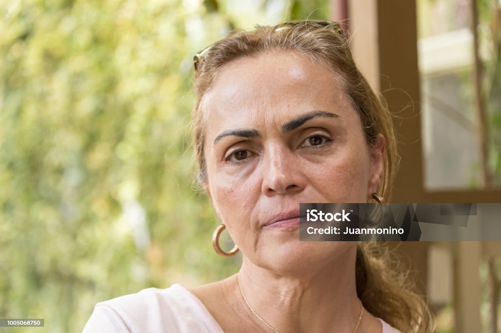 Sad pensive mature woman Concerned mature hispanic or middle eastern woman looking at the camera concerned Women Stock Photo