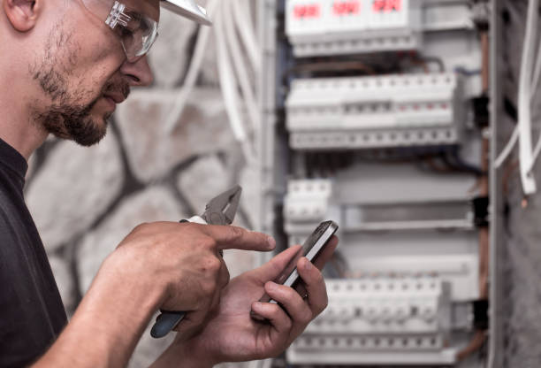 istock a male electrician works in a switchboard with an electrical connecting cable 1005068982