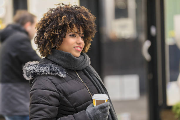 istock Young black woman drinking coffee at street 1005076334