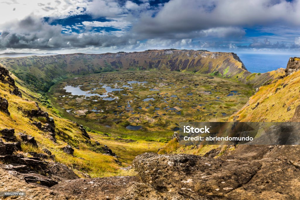 Amazing view over Rano Kau Volcano, maybe the most impressive landscape inside Easter Island. Easter Island a mystic place in the middle of the Pacific Ocean, maybe the most remote area in the world if we take onto consideration the distance to the mainland, Moais standing facing the elements and remembering and old amazing culture Kau District Stock Photo