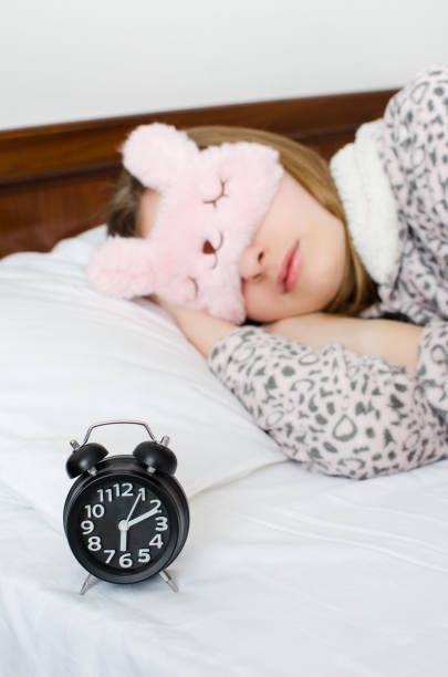 istock Woman sleeping with alarm clock 1005124234