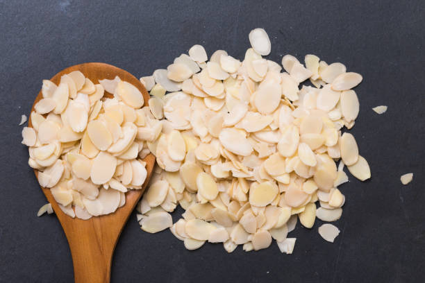 Sliced almonds on dark granite blackground stock photo