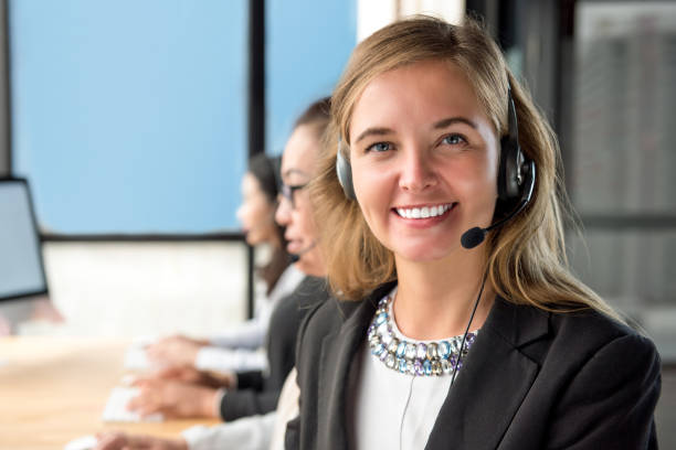 agente de servicio al cliente mujer hermosa trabajando en call center con su equipo - phoneline fotografías e imágenes de stock