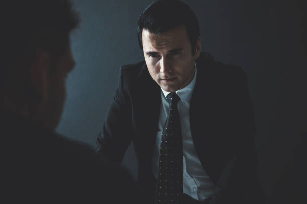 istock Detective interviewing criminal man in interrogation room 1005124808
