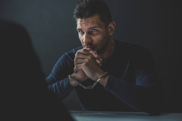 istock Suspect or criminal man with handcuffs  in interrogation room 1005124810