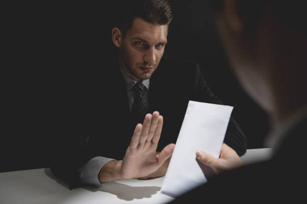istock Businessman rejecting money in white envelope offered by his partner 1005124854
