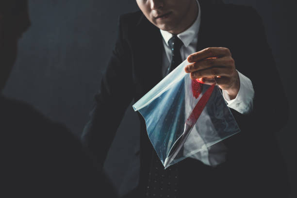 Officer showing an evidence in crime investigation Officer intervieing criminal man showing a knife with blood as an evidence in crime investigation evidence bag stock pictures, royalty-free photos & images